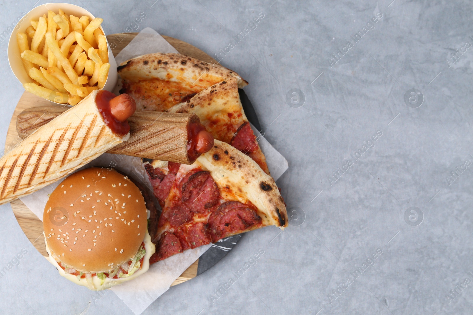 Different delicious fast food on grey table, top view. Space for text Photo of Different delicious fast food on grey table, top view. Space for text
