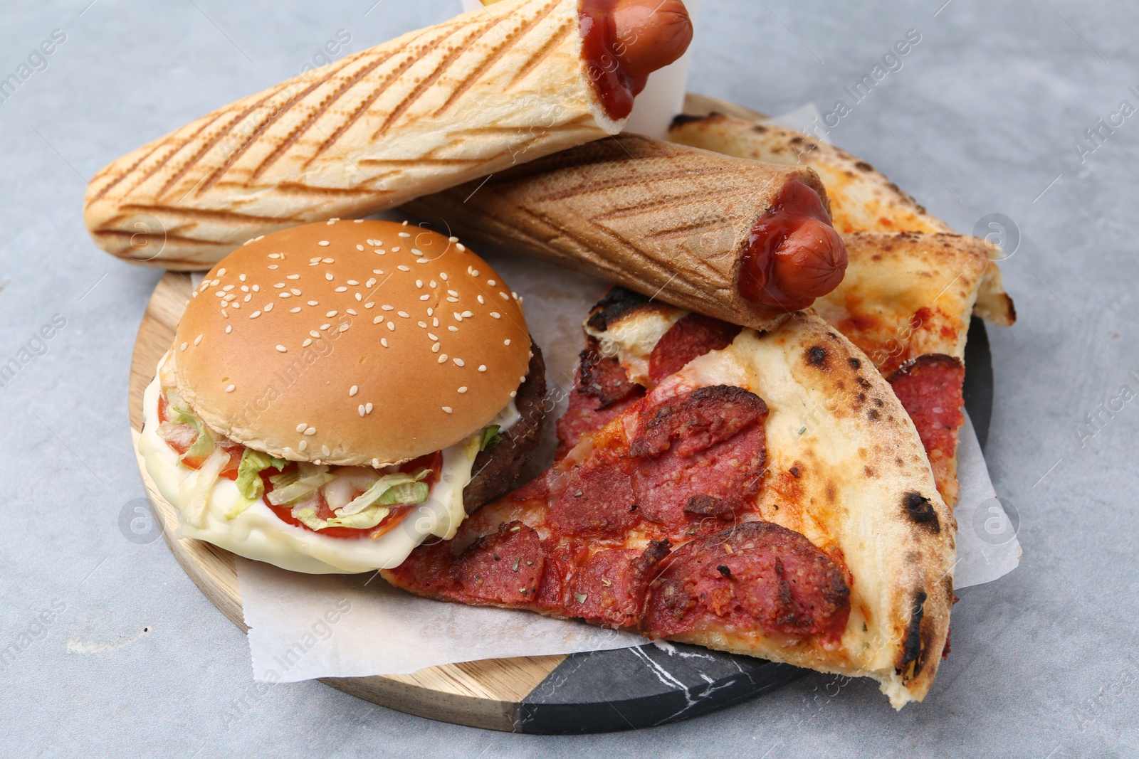 Different delicious fast food on grey table, closeup Photo of Different delicious fast food on grey table, closeup