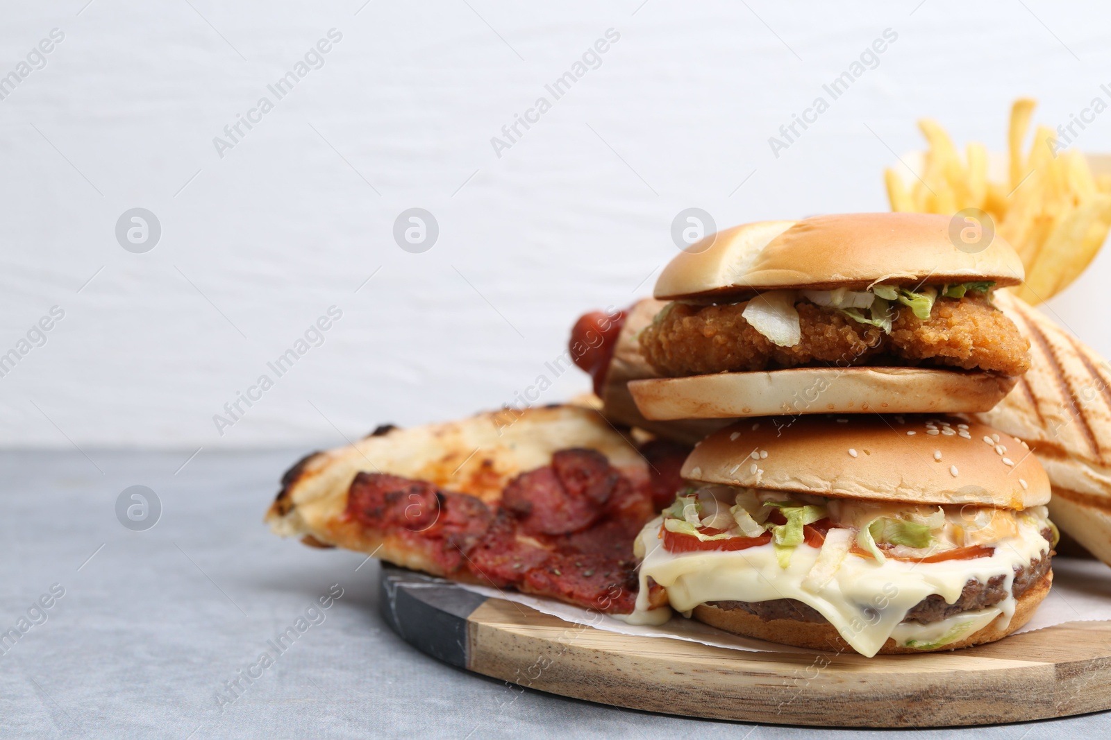 Different delicious fast food on grey table, closeup. Space for text Photo of Different delicious fast food on grey table, closeup. Space for text