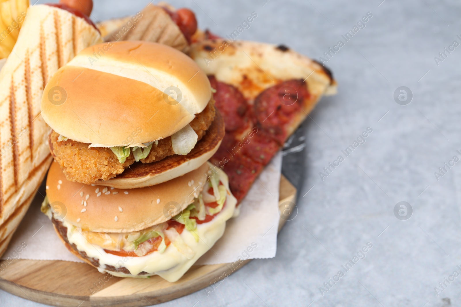Different delicious fast food on grey table, closeup. Space for text Photo of Different delicious fast food on grey table, closeup. Space for text