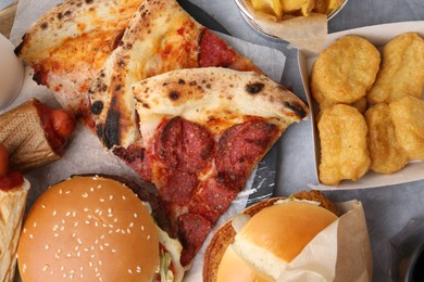 Photo of Different delicious fast food on grey table, flat lay
