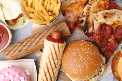 Photo of Different delicious fast food on grey table, flat lay