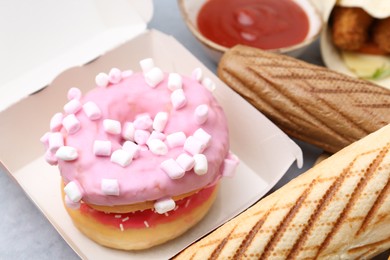 Photo of Different delicious fast food and soda drink on grey table, closeup