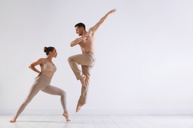 Photo of Couple of professional dancers training in studio. Space for text