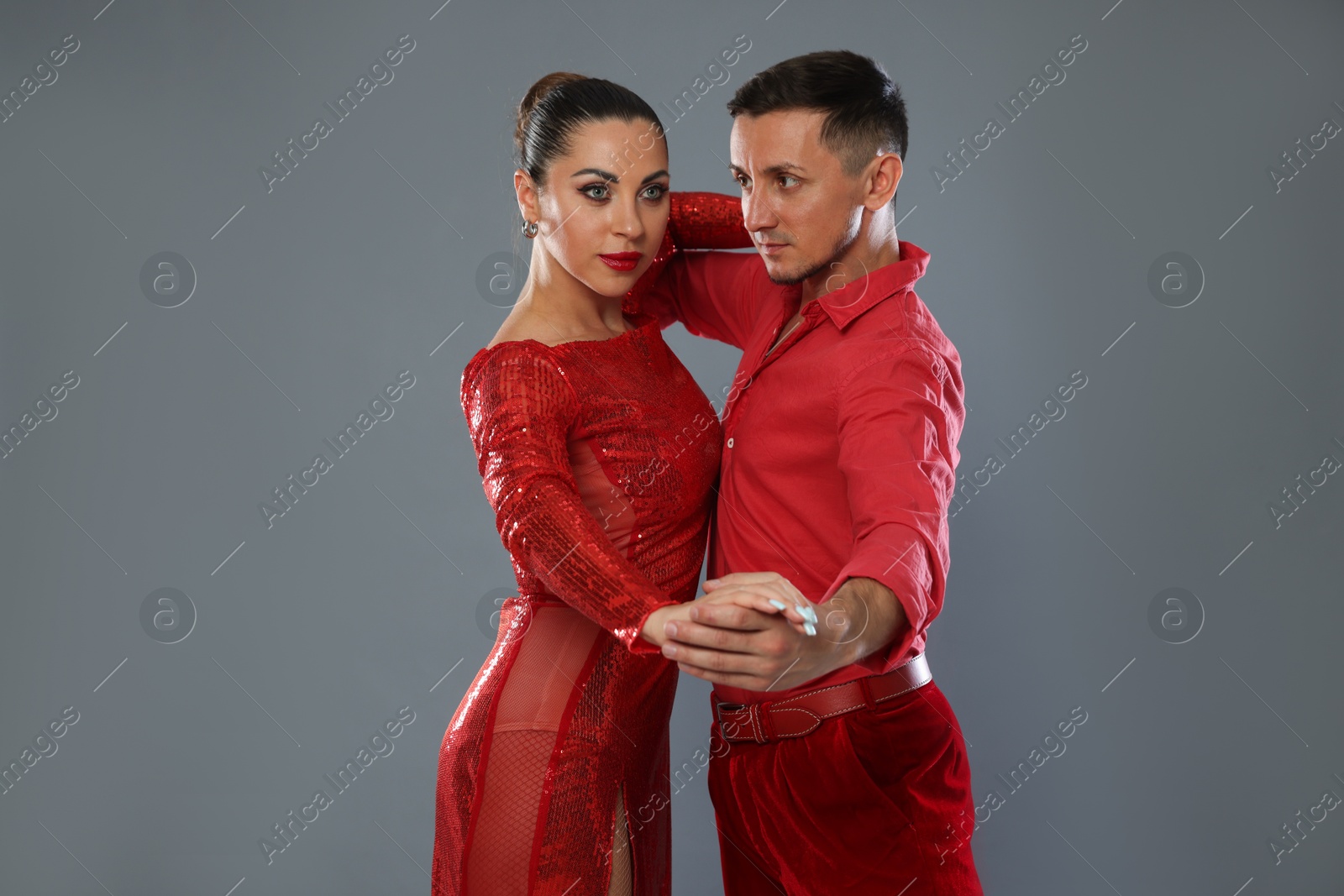 Couple of professional dancers on gray background Photo of Couple of professional dancers on gray background