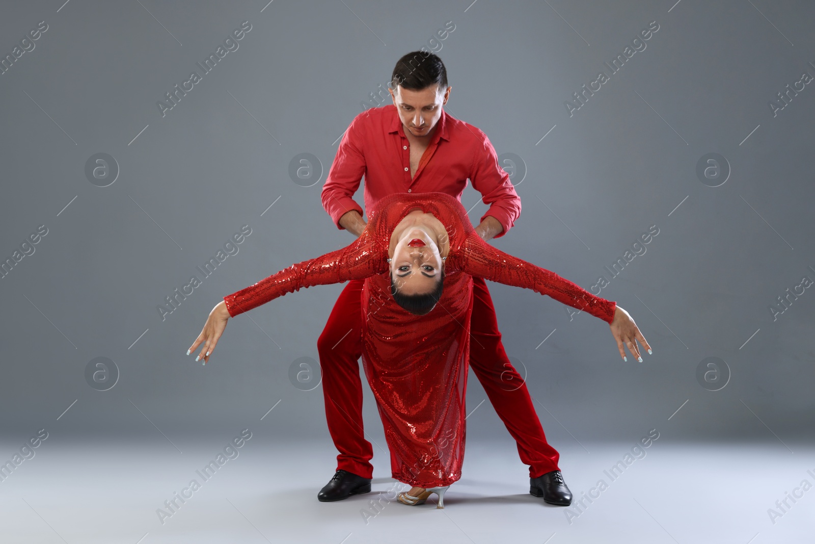 Couple of professional dancers on gray background Photo of Couple of professional dancers on gray background