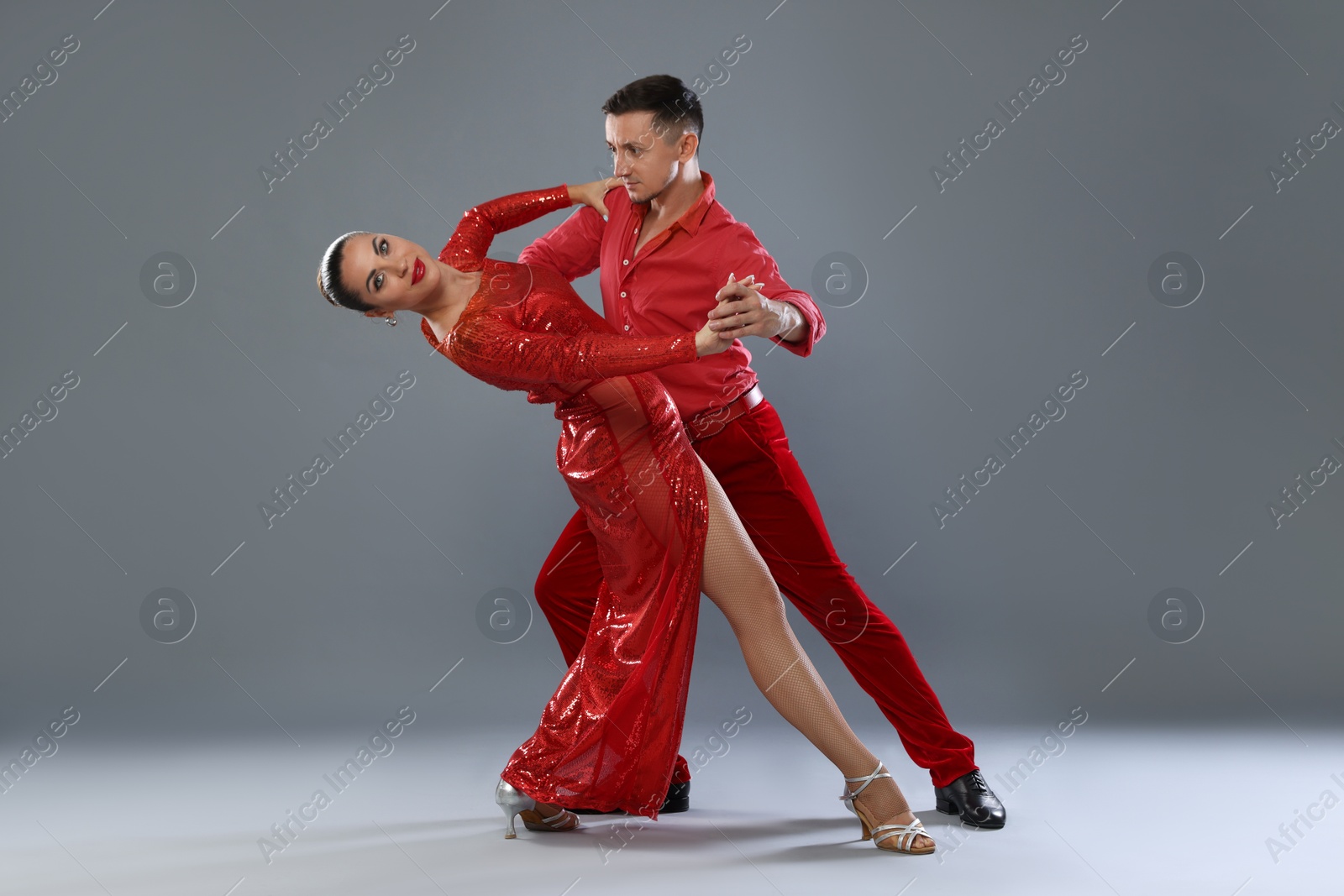 Couple of professional dancers on gray background Photo of Couple of professional dancers on gray background