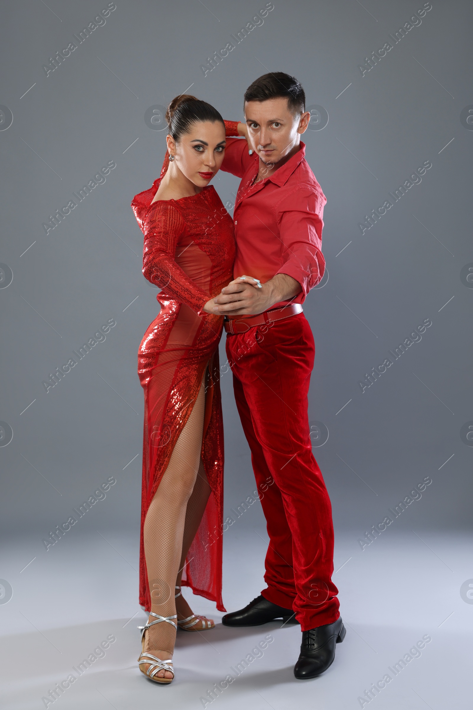Couple of professional dancers on gray background Photo of Couple of professional dancers on gray background