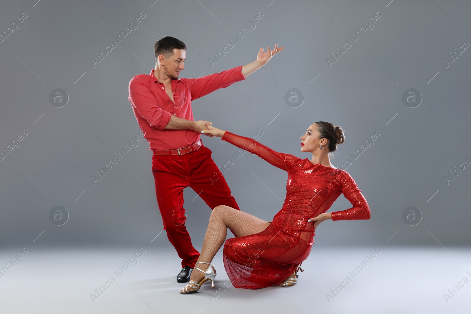 Couple of professional dancers on gray background Photo of Couple of professional dancers on gray background