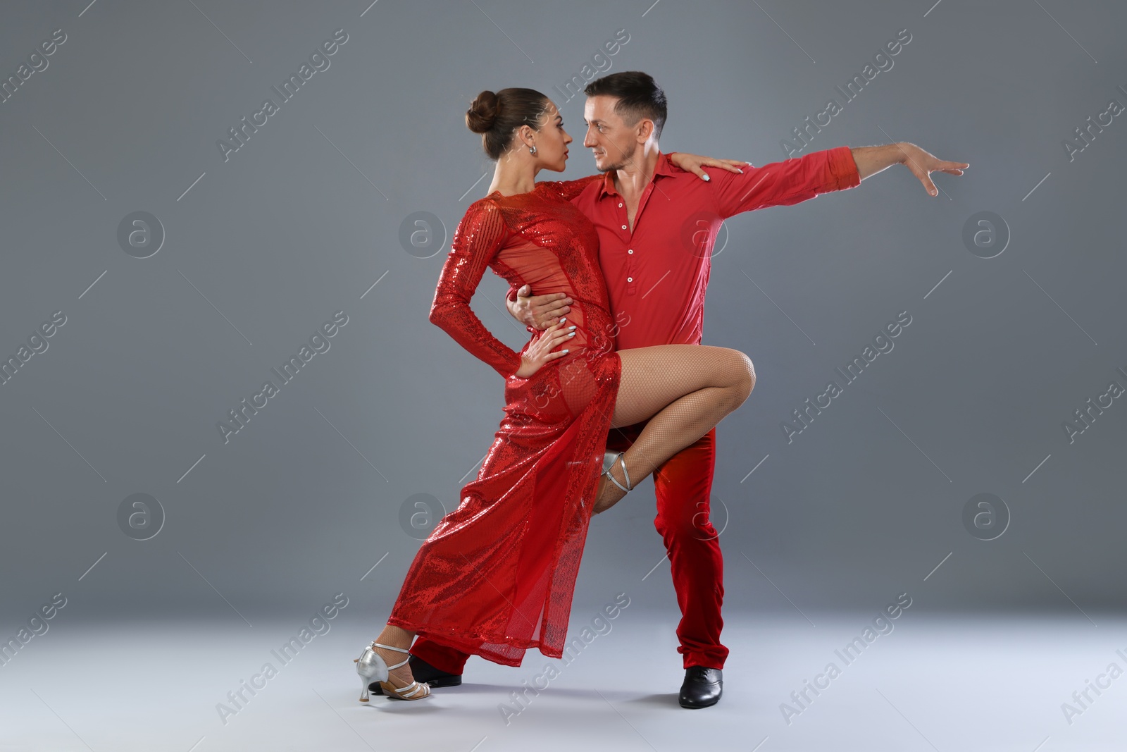 Couple of professional dancers on gray background Photo of Couple of professional dancers on gray background