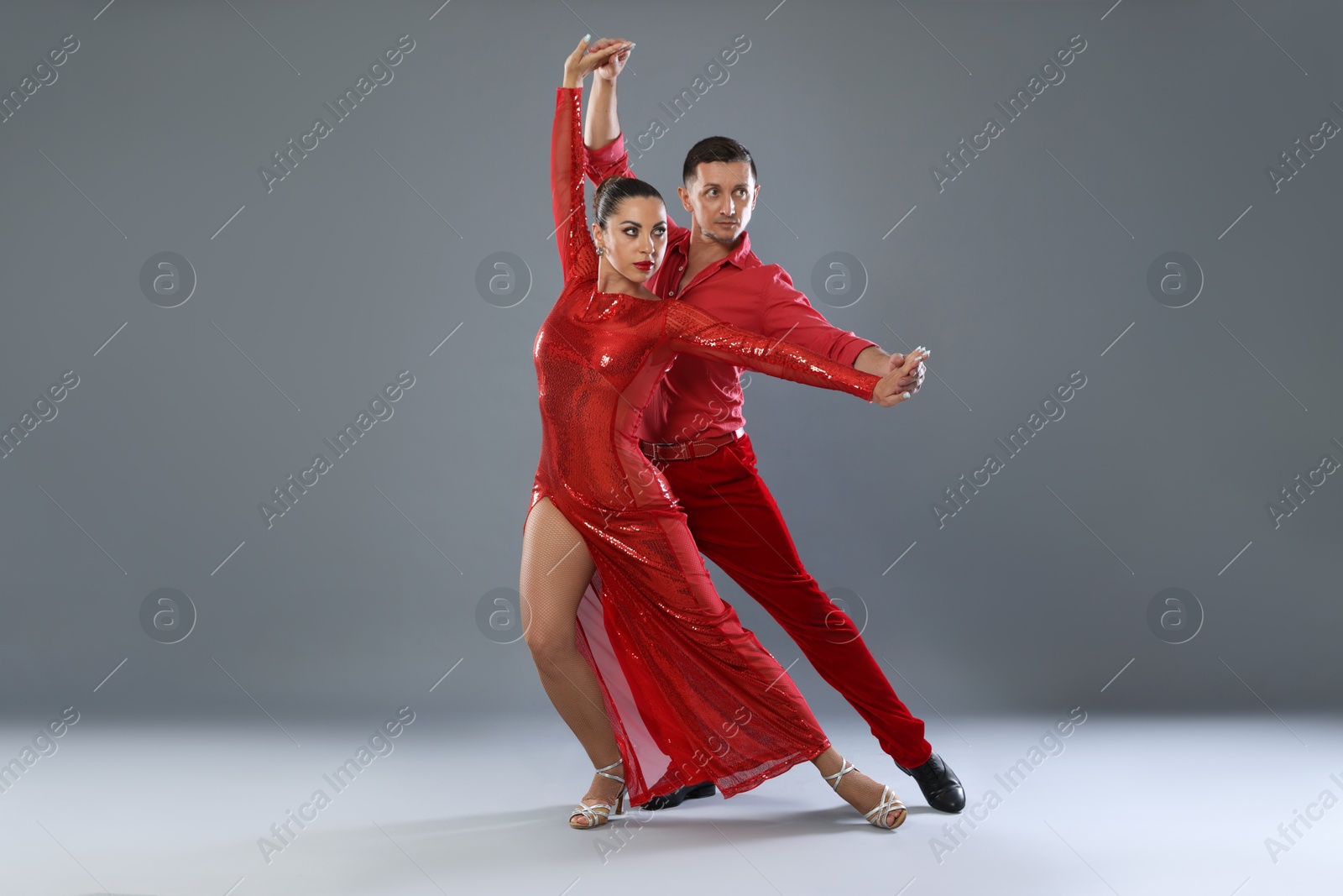 Couple of professional dancers on gray background Photo of Couple of professional dancers on gray background