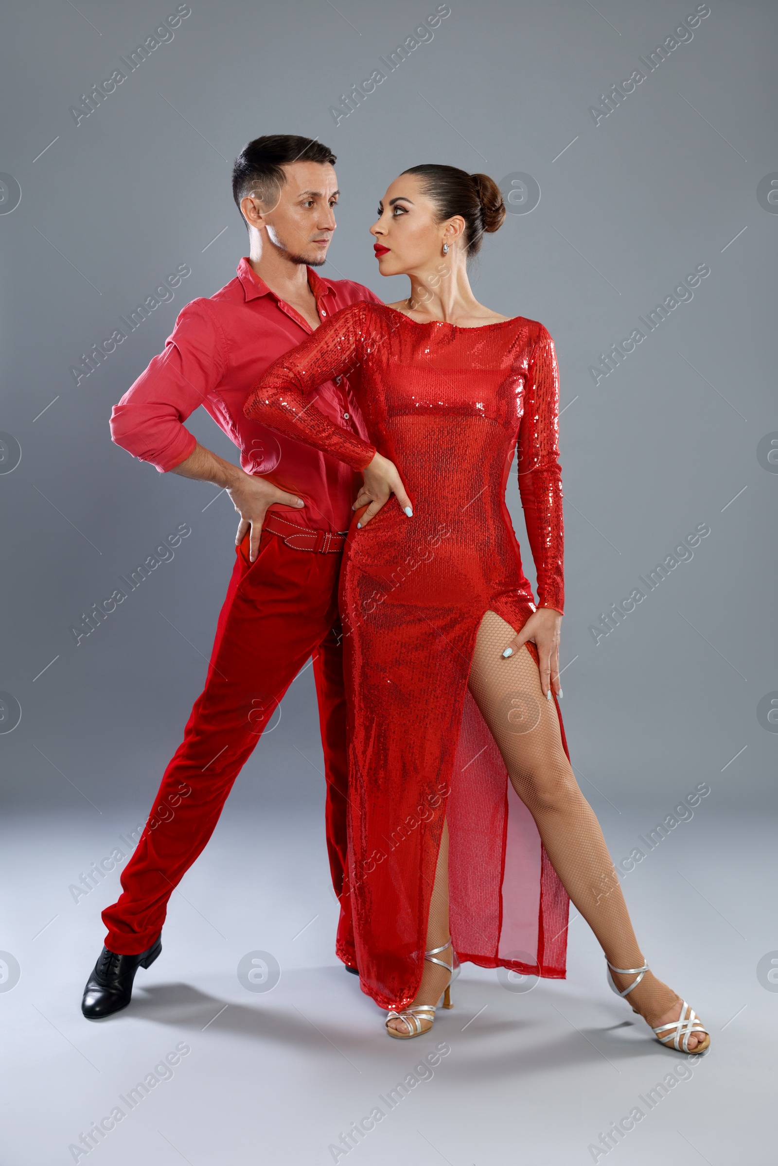 Couple of professional dancers on gray background Photo of Couple of professional dancers on gray background