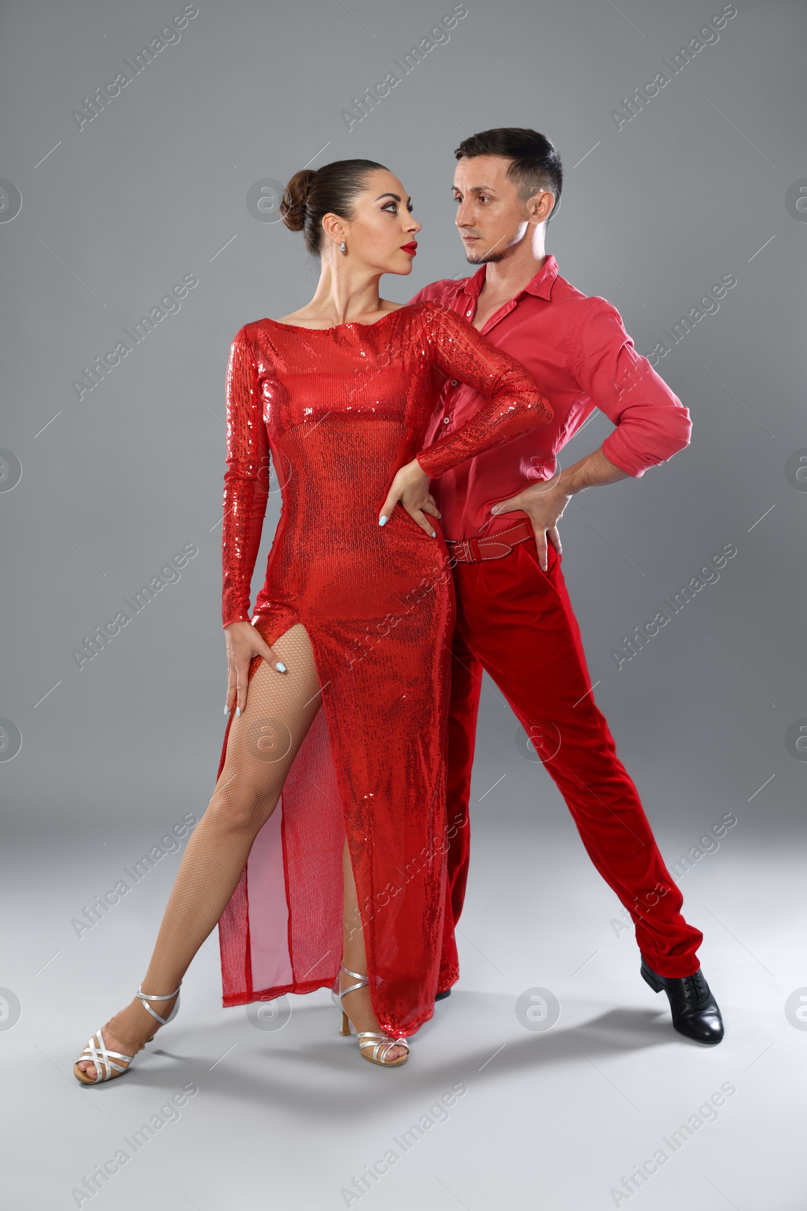 Couple of professional dancers on gray background Photo of Couple of professional dancers on gray background