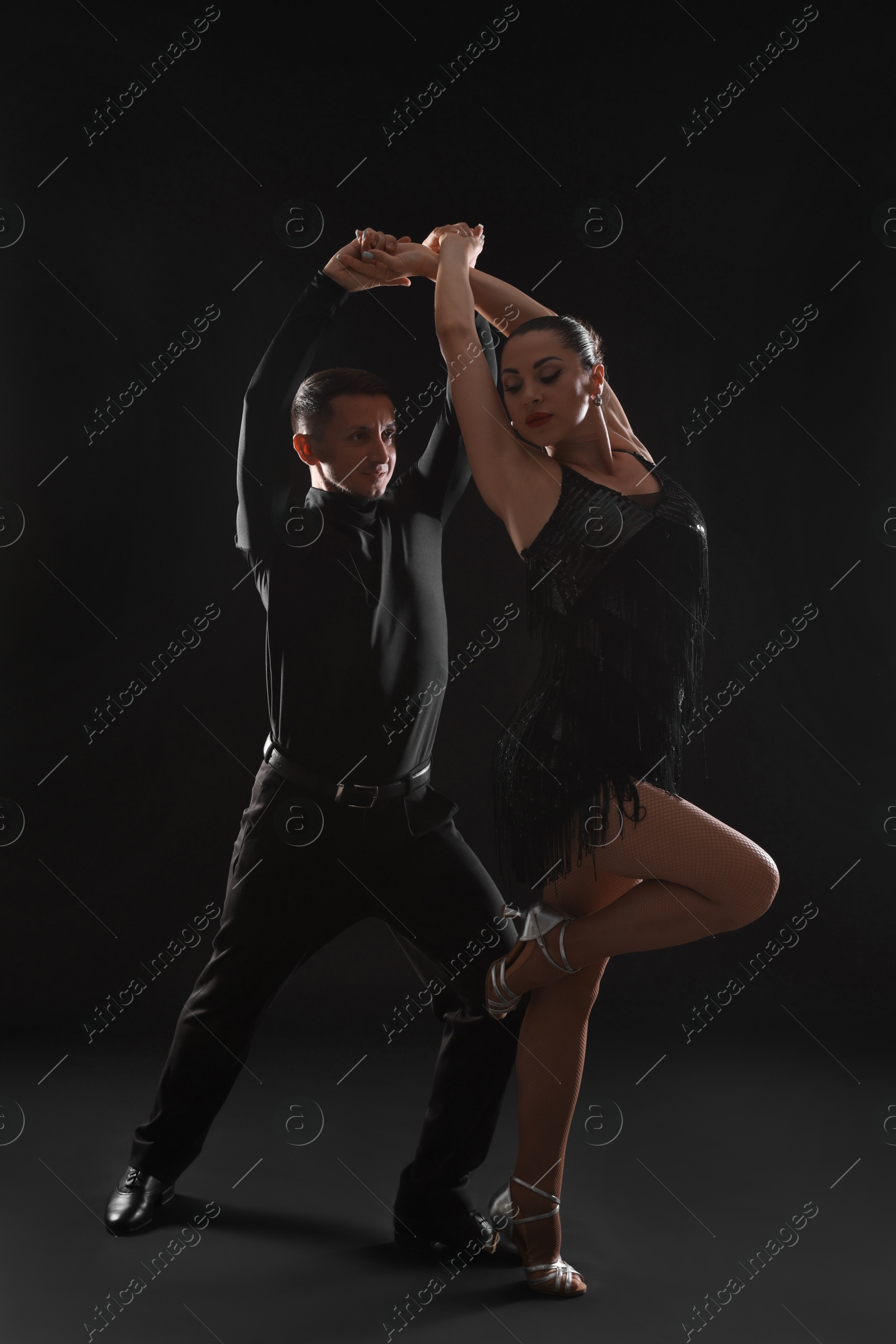 Couple of professional dancers on dark background Photo of Couple of professional dancers on dark background