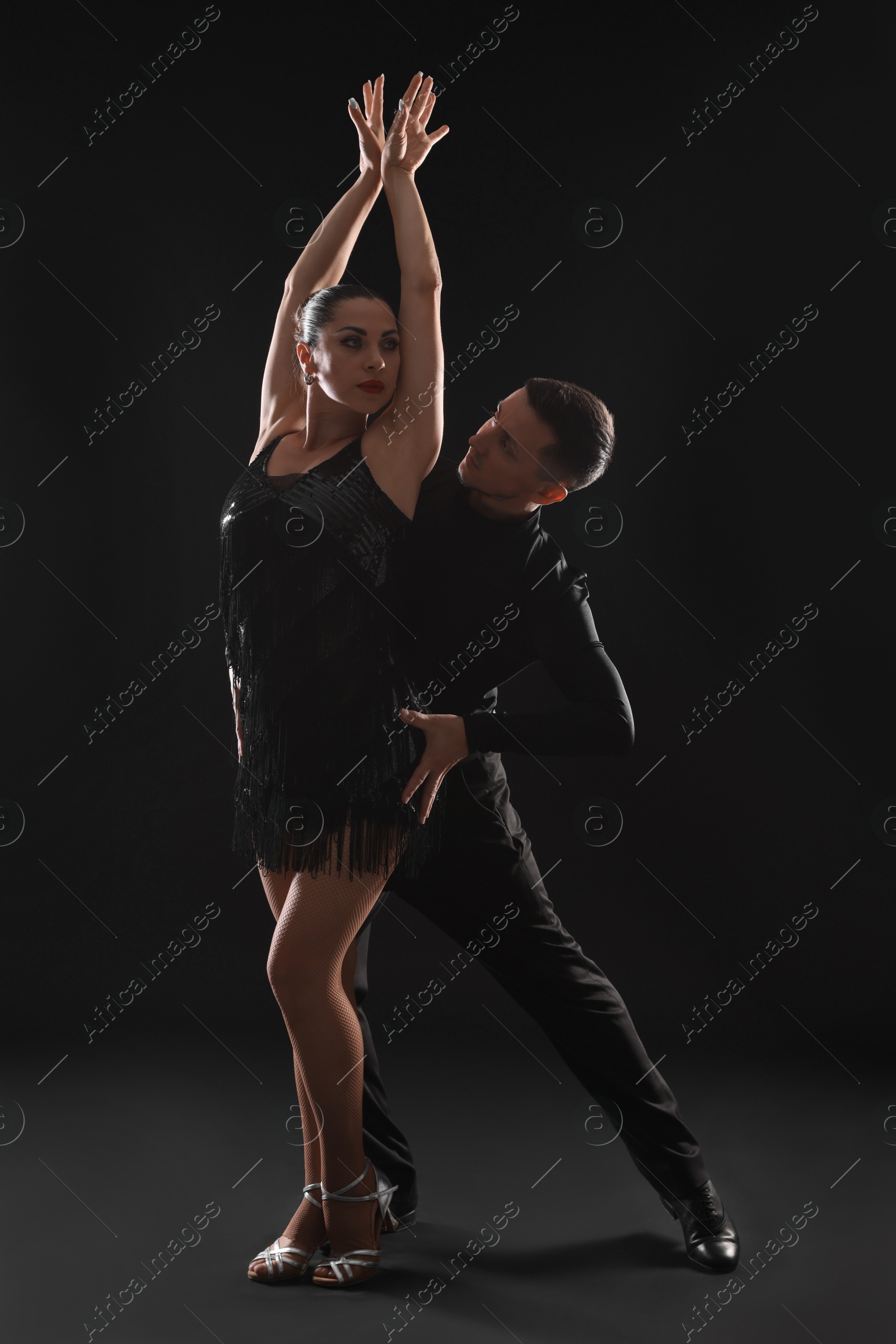 Couple of professional dancers on dark background Photo of Couple of professional dancers on dark background