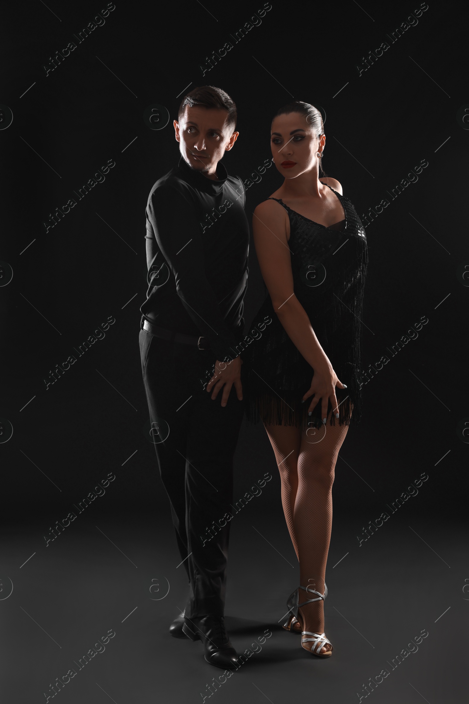 Couple of professional dancers on dark background Photo of Couple of professional dancers on dark background