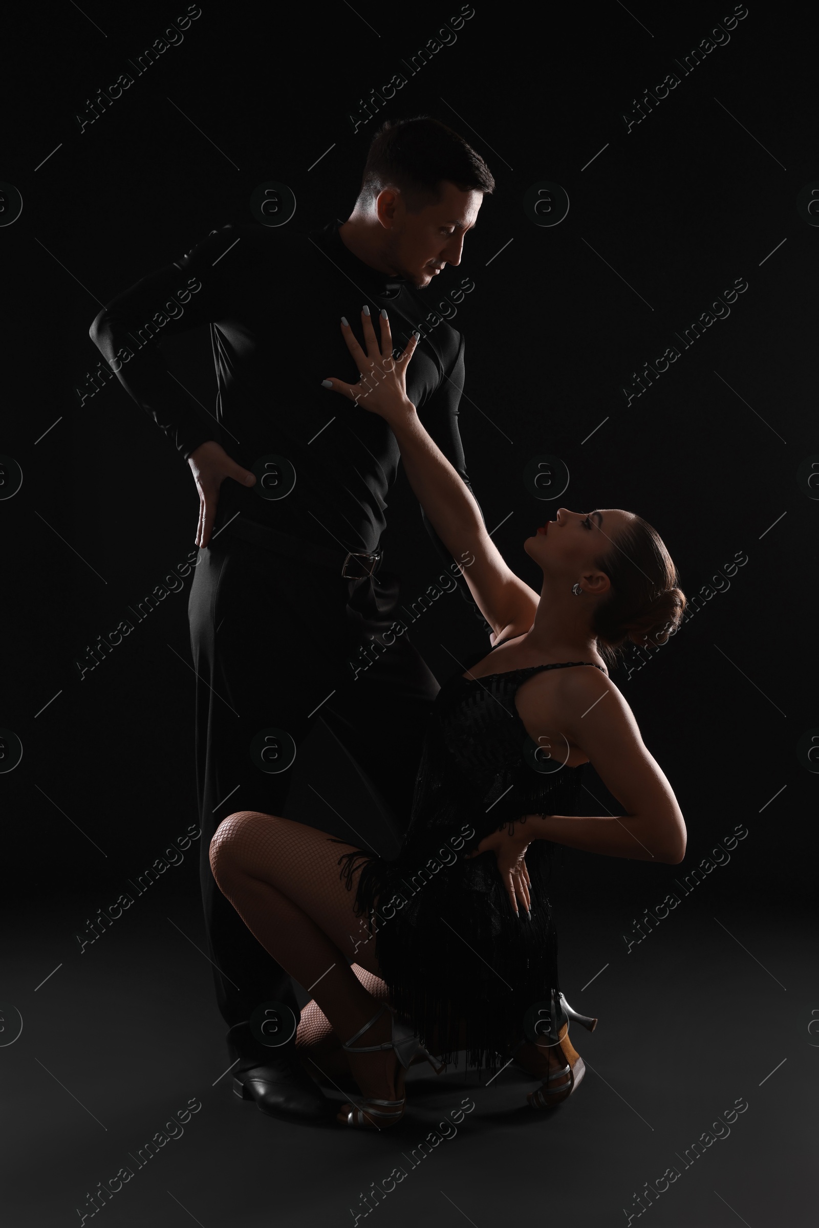 Couple of professional dancers on dark background Photo of Couple of professional dancers on dark background