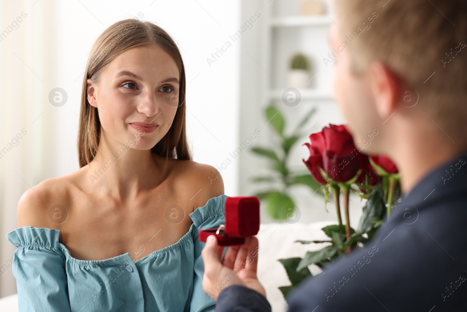 Man with engagement ring and bouquet of roses making marriage proposal to his girlfriend at home, closeup Photo of Man with engagement ring and bouquet of roses making marriage proposal to his girlfriend at home, closeup