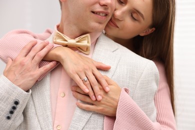 Photo of Making marriage proposal. Woman with engagement ring and her smiling fiance hugging at home, closeup
