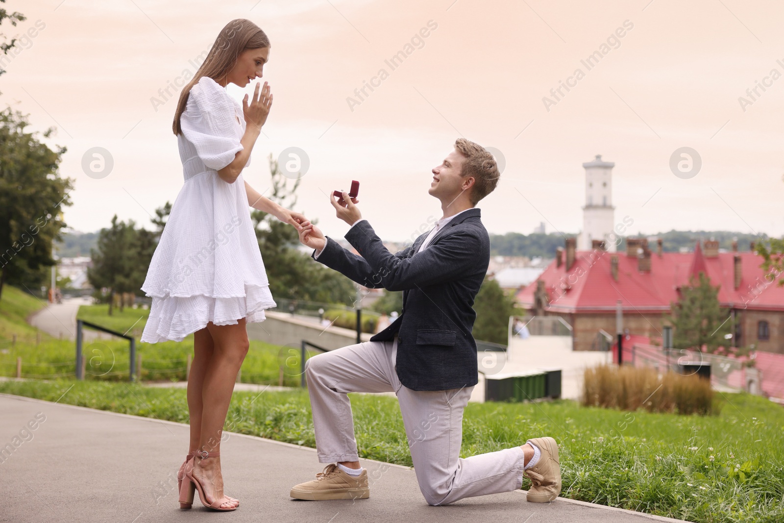 Smiling man with engagement ring making marriage proposal to his surprised girlfriend outdoors Photo of Smiling man with engagement ring making marriage proposal to his surprised girlfriend outdoors