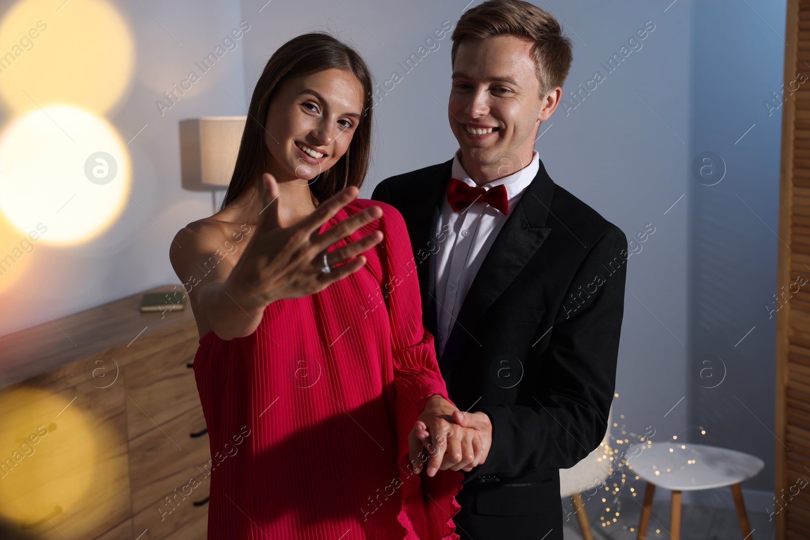 Making marriage proposal. Happy girlfriend showing engagement ring and her fiance at home. Bokeh effect Photo of Making marriage proposal. Happy girlfriend showing engagement ring and her fiance at home. Bokeh effect
