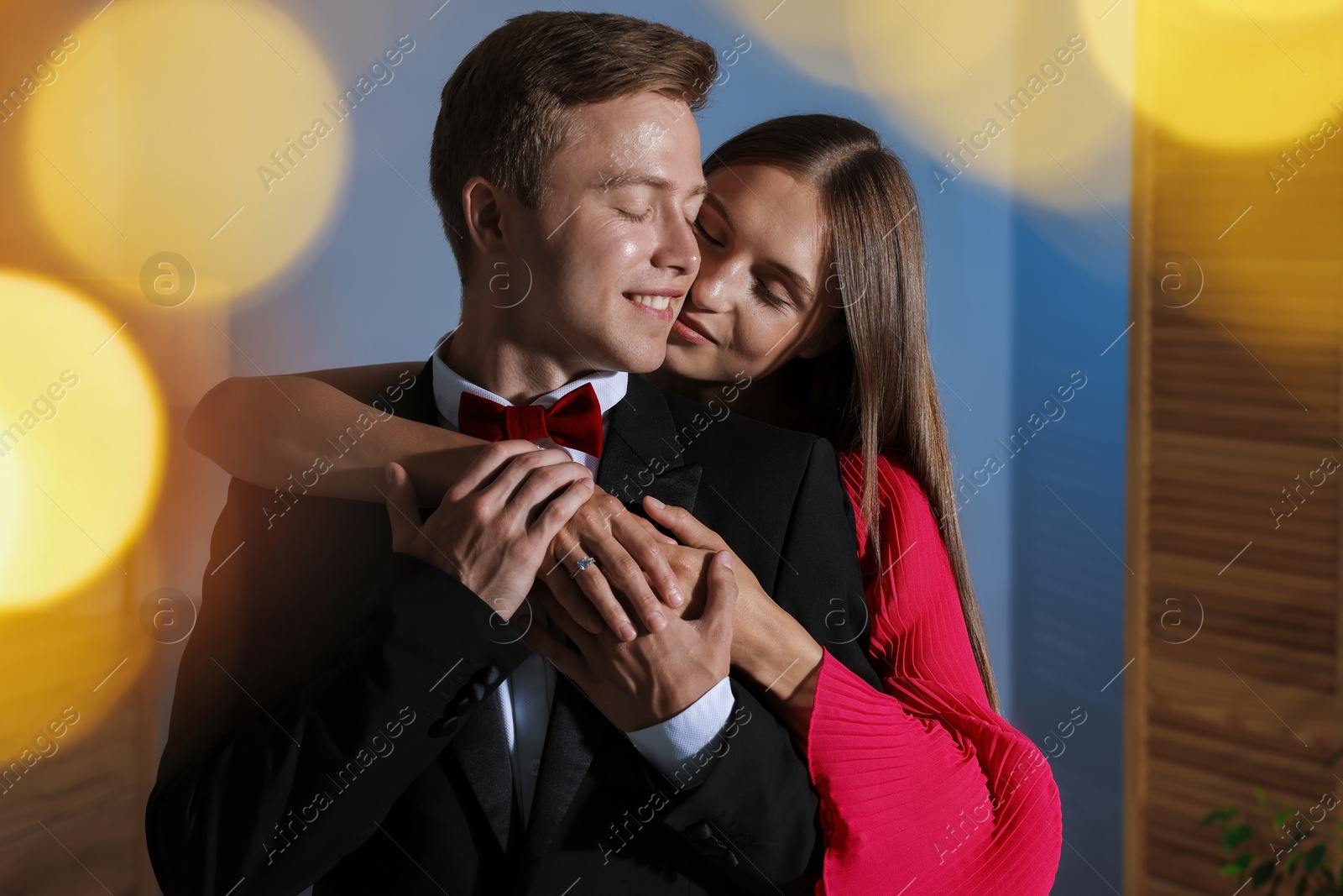 Making marriage proposal. Woman with engagement ring and her smiling fiance hugging at home. Bokeh effect Photo of Making marriage proposal. Woman with engagement ring and her smiling fiance hugging at home. Bokeh effect