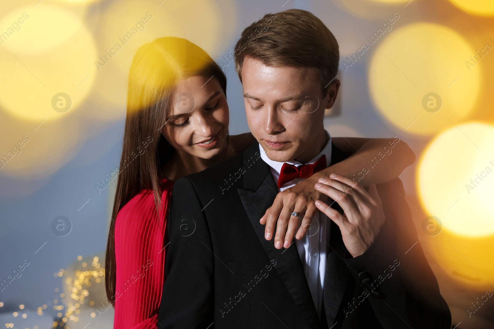 Making marriage proposal. Smiling woman with engagement ring and her fiance hugging at home. Bokeh effect Photo of Making marriage proposal. Smiling woman with engagement ring and her fiance hugging at home. Bokeh effect