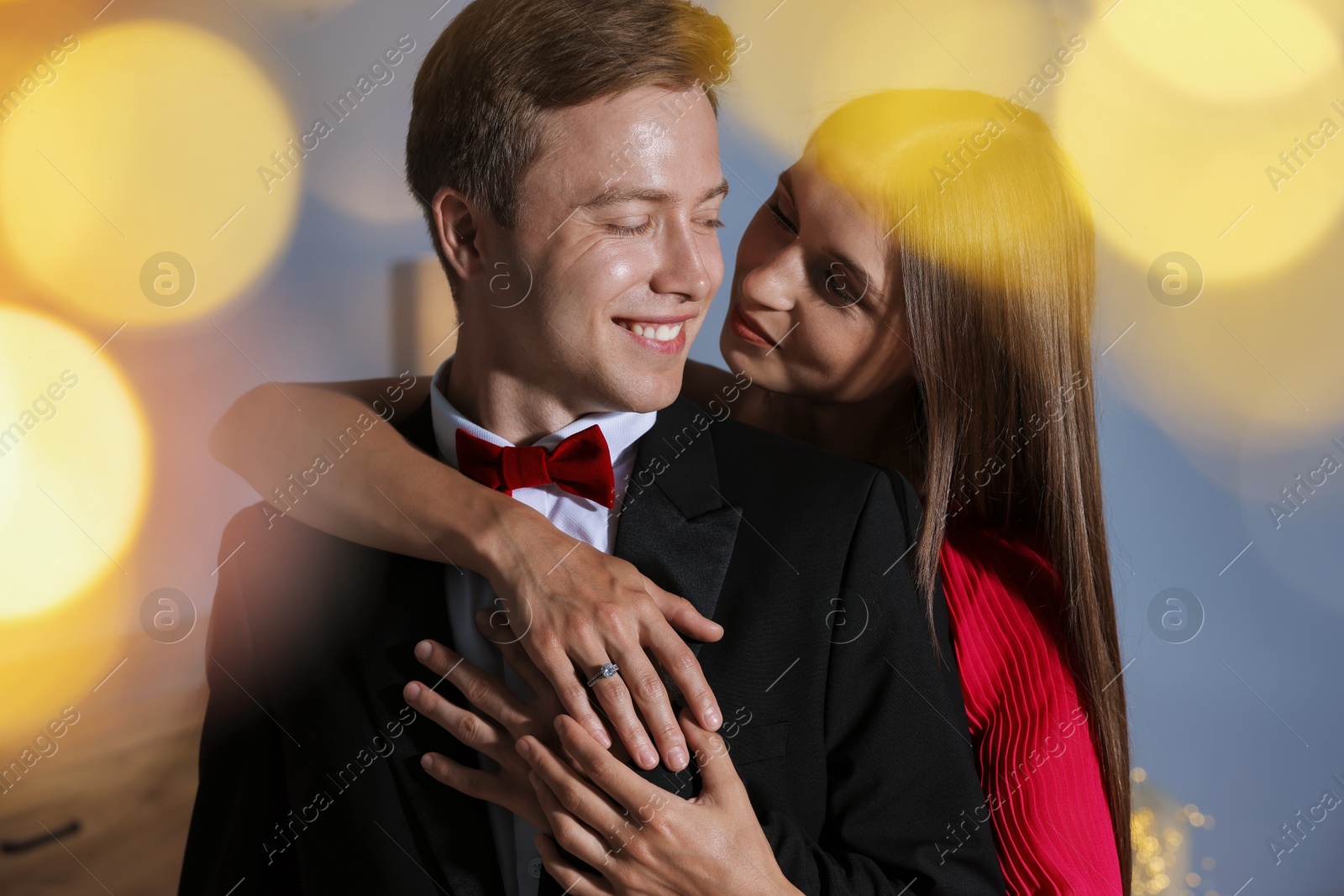 Making marriage proposal. Woman with engagement ring and her smiling fiance hugging at home. Bokeh effect Photo of Making marriage proposal. Woman with engagement ring and her smiling fiance hugging at home. Bokeh effect