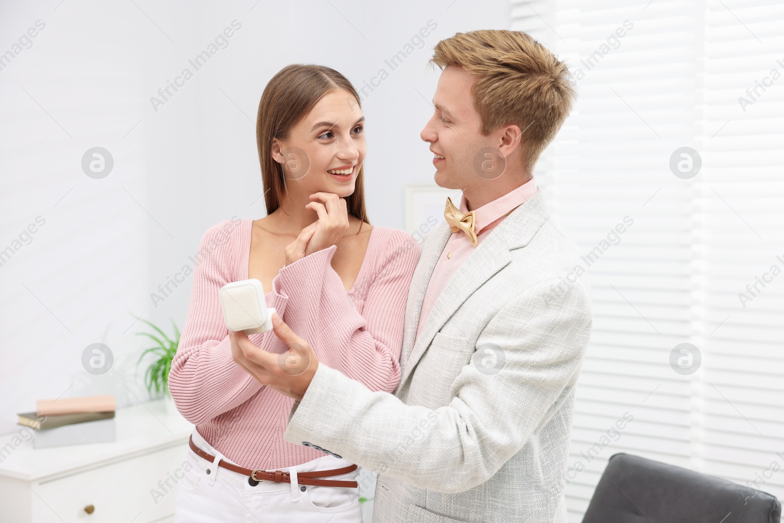Smiling man with engagement ring making marriage proposal to his happy girlfriend at home Photo of Smiling man with engagement ring making marriage proposal to his happy girlfriend at home