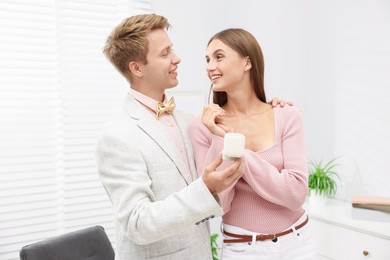 Photo of Marriage proposal. Smiling man with engagement ring and his happy girlfriend at home