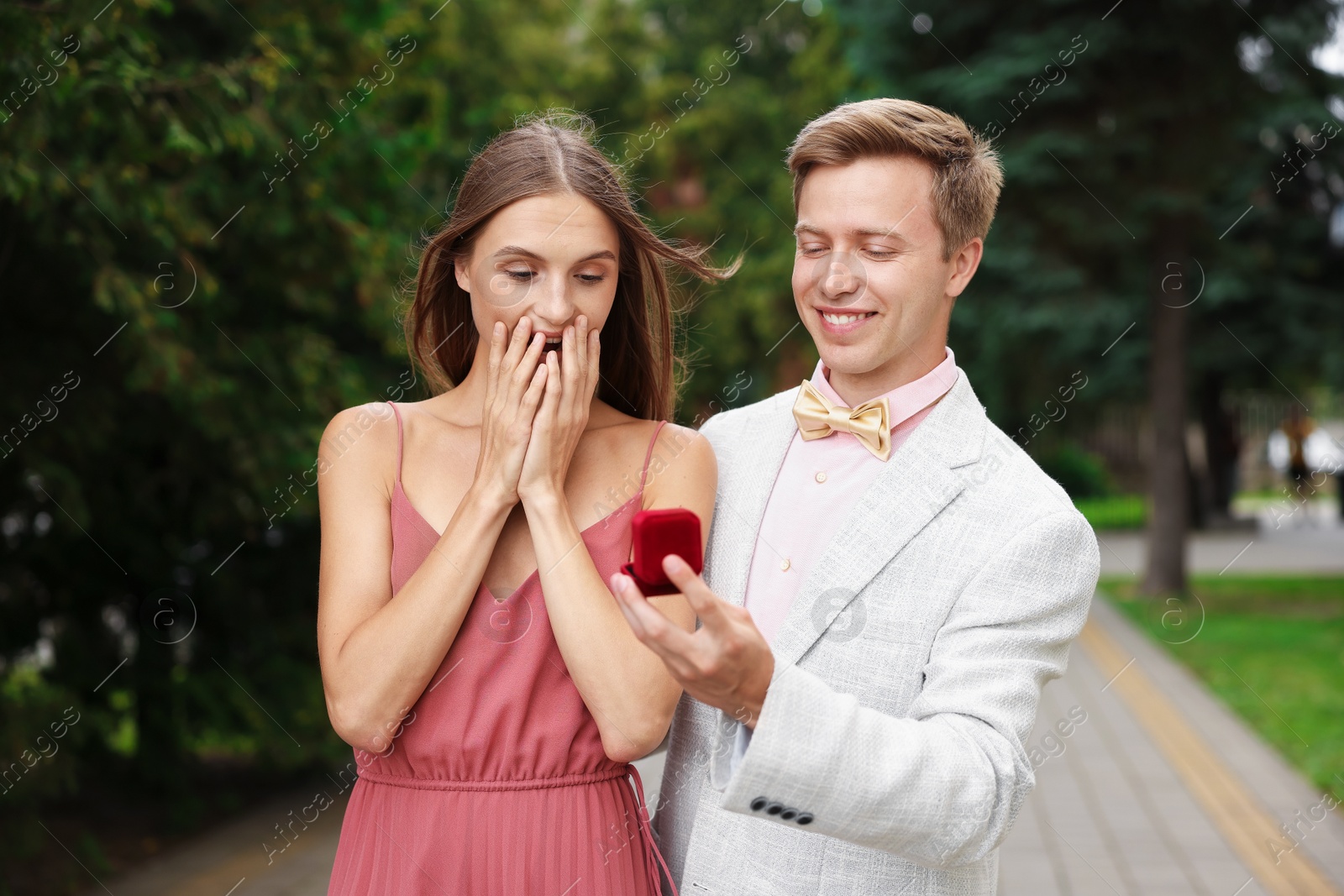 Smiling man with engagement ring making marriage proposal to his surprised girlfriend outdoors Photo of Smiling man with engagement ring making marriage proposal to his surprised girlfriend outdoors