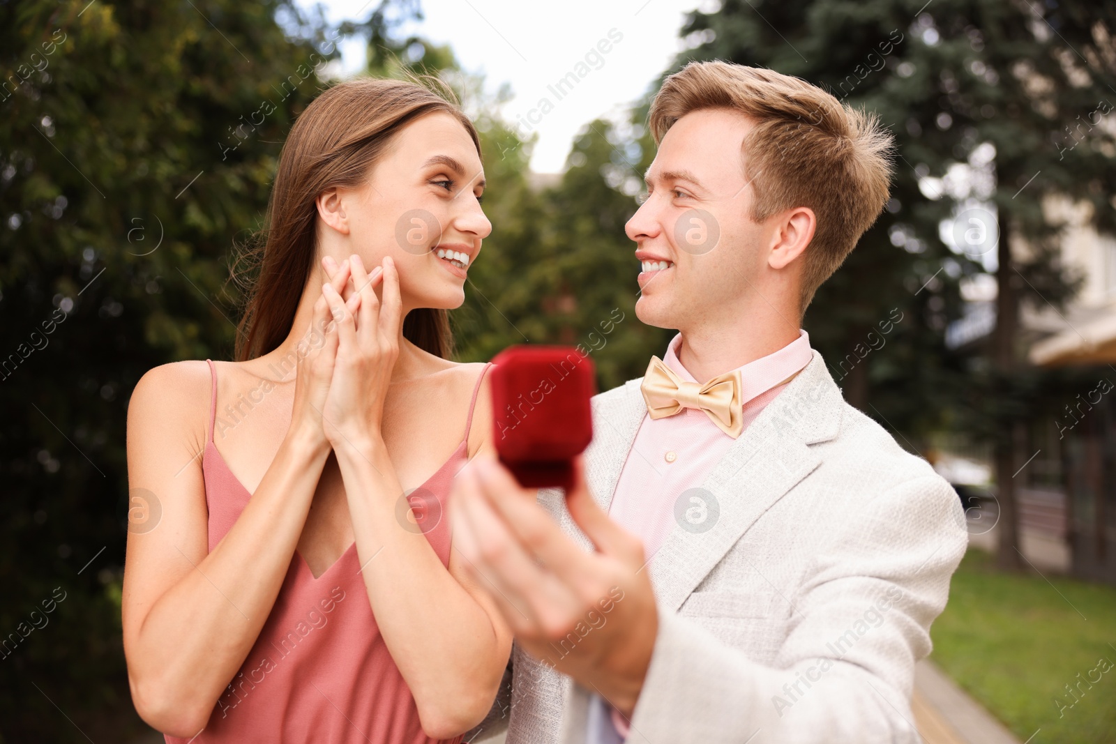 Smiling man with engagement ring making marriage proposal to his surprised girlfriend outdoors Photo of Smiling man with engagement ring making marriage proposal to his surprised girlfriend outdoors