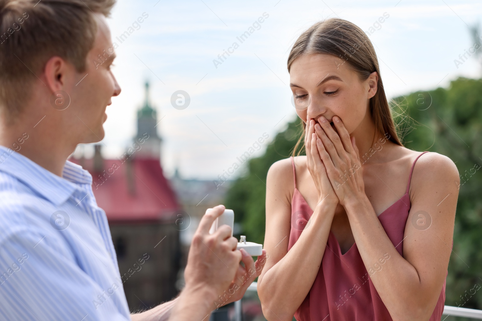 Man with engagement ring making marriage proposal to his surprised girlfriend outdoors Photo of Man with engagement ring making marriage proposal to his surprised girlfriend outdoors