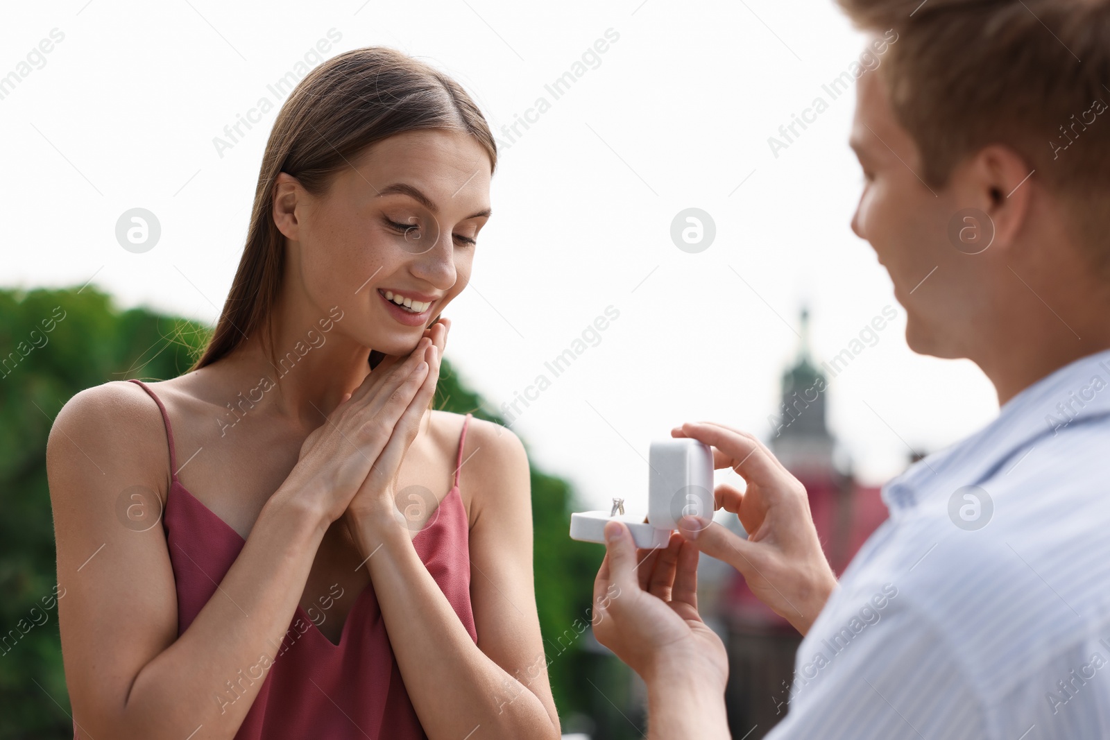 Man with engagement ring making marriage proposal to his happy girlfriend outdoors Photo of Man with engagement ring making marriage proposal to his happy girlfriend outdoors
