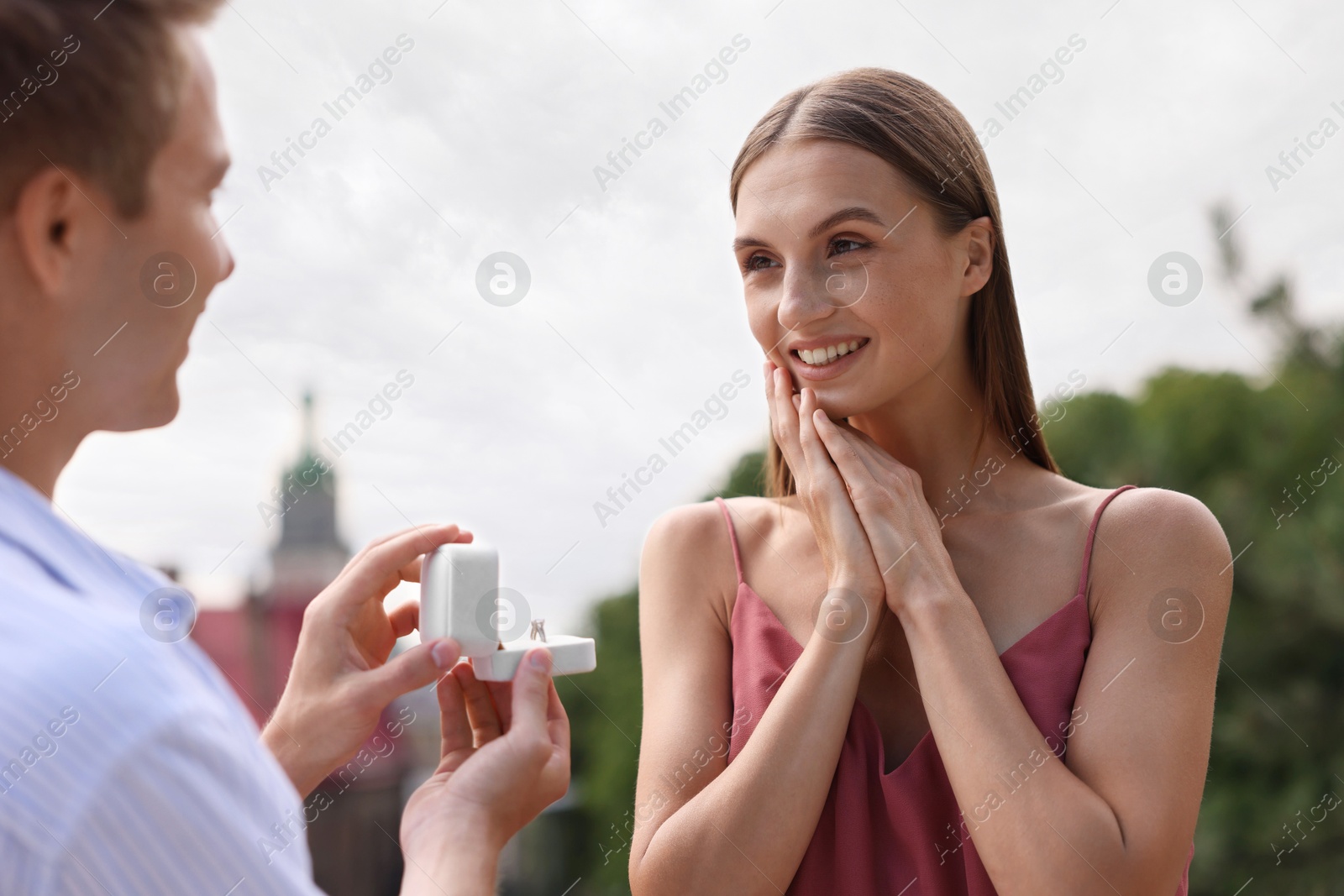 Man with engagement ring making marriage proposal to his happy girlfriend outdoors Photo of Man with engagement ring making marriage proposal to his happy girlfriend outdoors