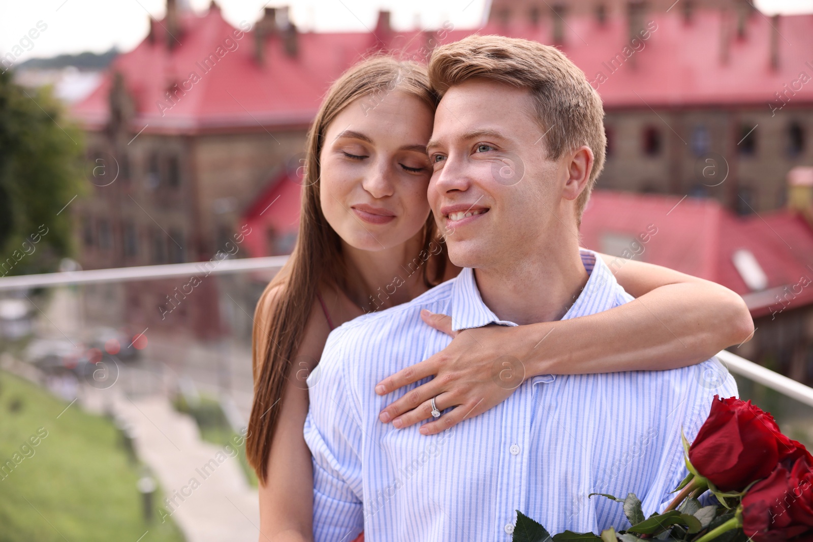 Making marriage proposal. Woman with engagement ring and her fiance hugging on balcony outdoors Photo of Making marriage proposal. Woman with engagement ring and her fiance hugging on balcony outdoors