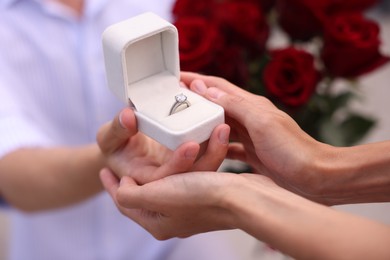 Photo of Man with engagement ring making marriage proposal to his girlfriend outdoors, closeup