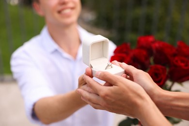 Photo of Man with engagement ring making marriage proposal to his girlfriend outdoors, closeup
