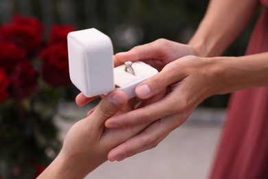 Photo of Man with engagement ring making marriage proposal to his girlfriend outdoors, closeup
