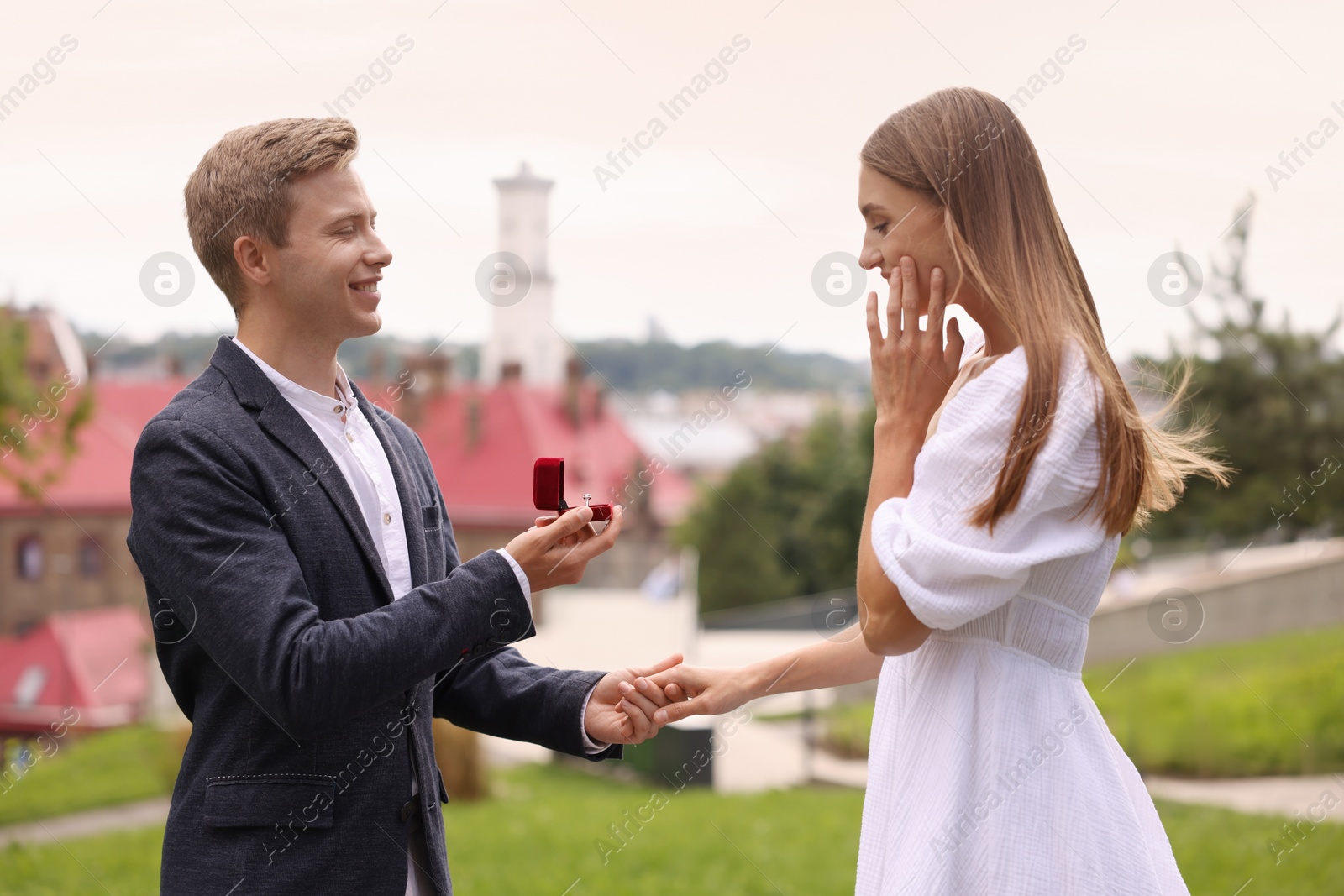 Smiling man with engagement ring making marriage proposal to his surprised girlfriend outdoors Photo of Smiling man with engagement ring making marriage proposal to his surprised girlfriend outdoors