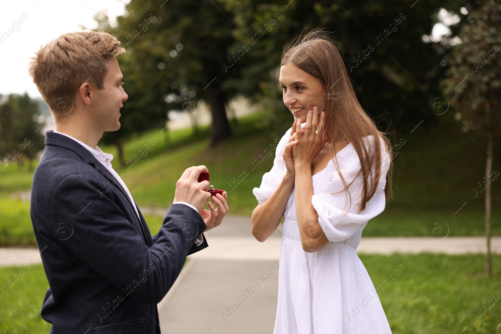 Man with engagement ring making marriage proposal to his happy girlfriend outdoors Photo of Man with engagement ring making marriage proposal to his happy girlfriend outdoors