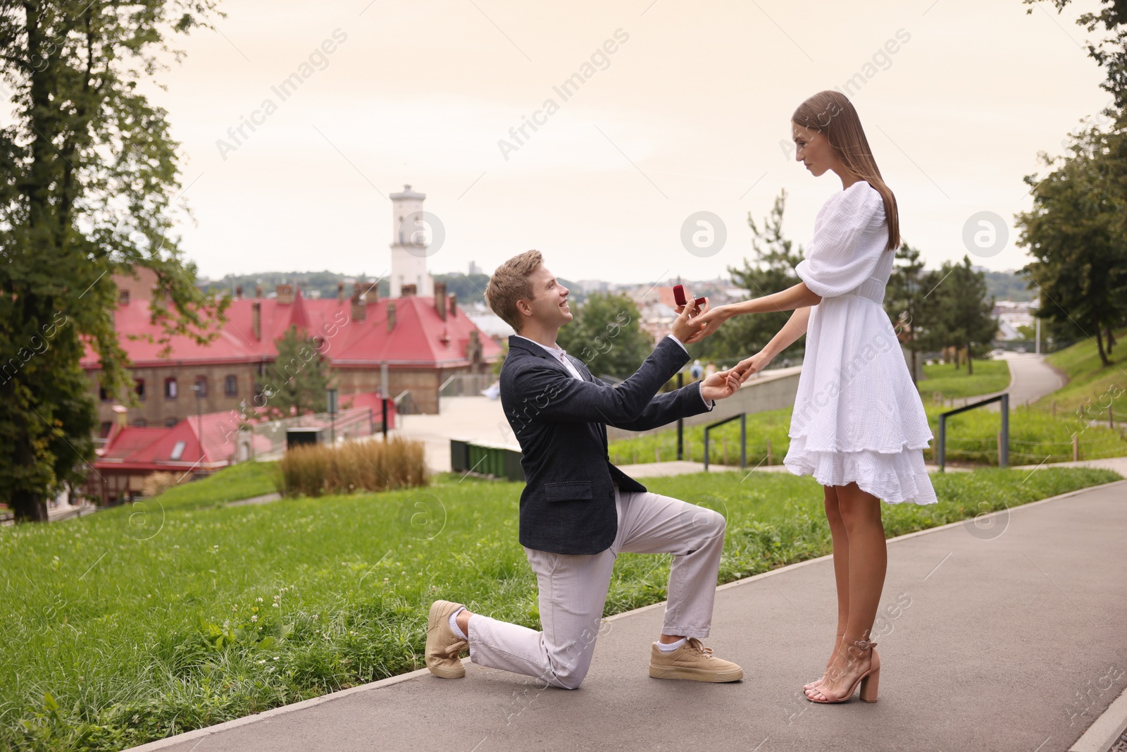 Smiling man with engagement ring making marriage proposal to his girlfriend outdoors. Space for text Photo of Smiling man with engagement ring making marriage proposal to his girlfriend outdoors. Space for text