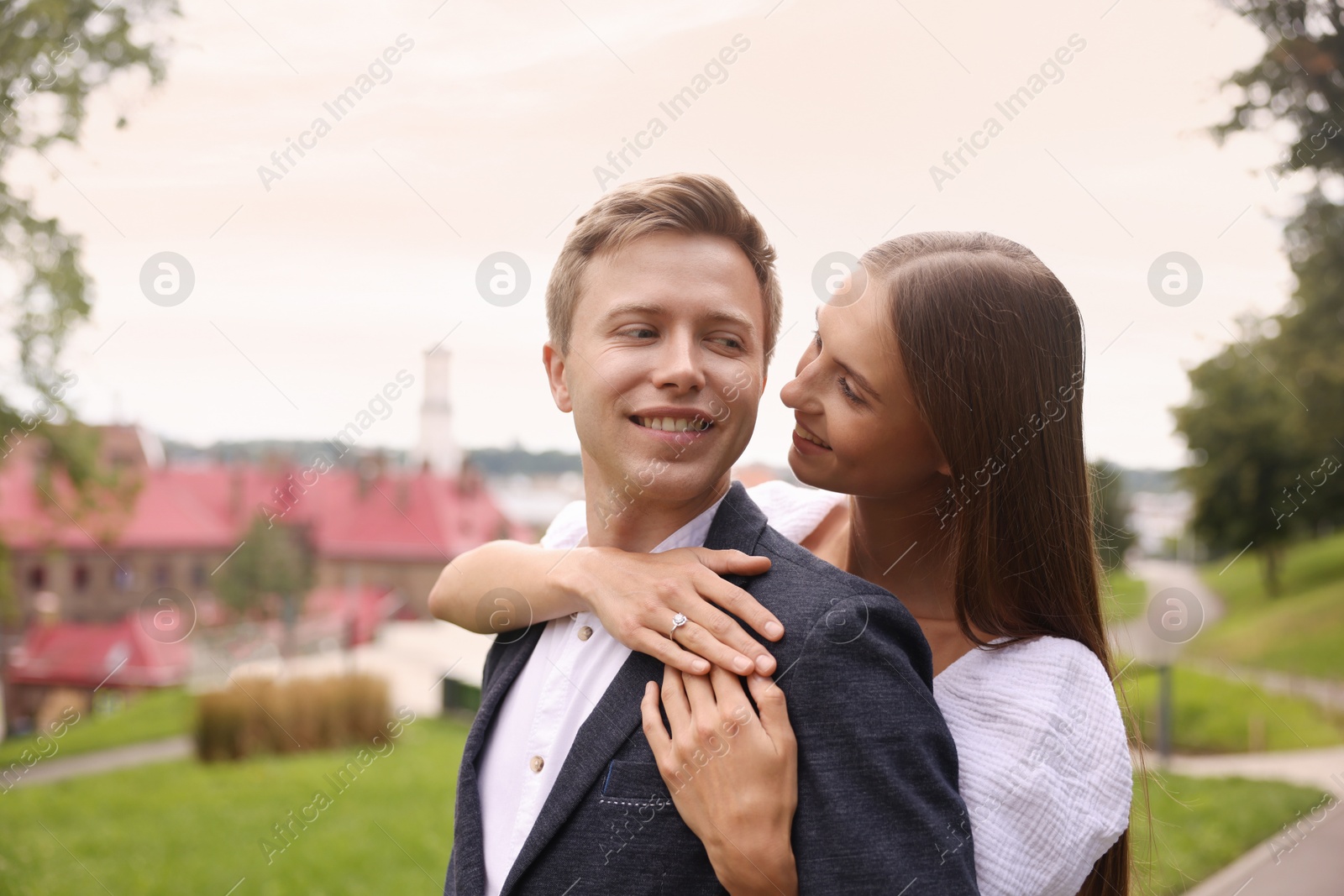 Marriage proposal. Woman with engagement ring hugging her smiling fiance outdoors, space for text Photo of Marriage proposal. Woman with engagement ring hugging her smiling fiance outdoors, space for text