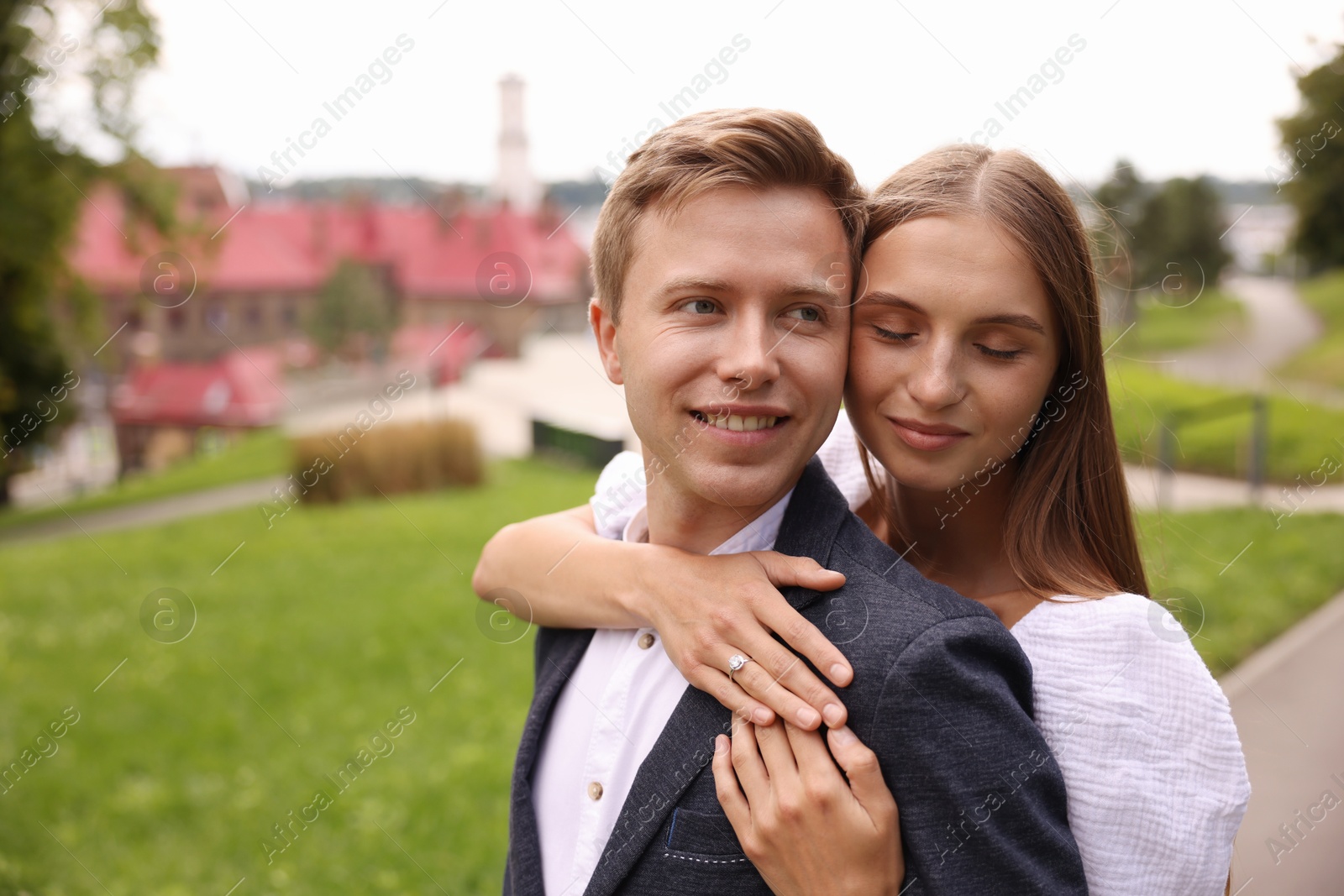 Marriage proposal. Woman with engagement ring hugging her smiling fiance outdoors, space for text Photo of Marriage proposal. Woman with engagement ring hugging her smiling fiance outdoors, space for text