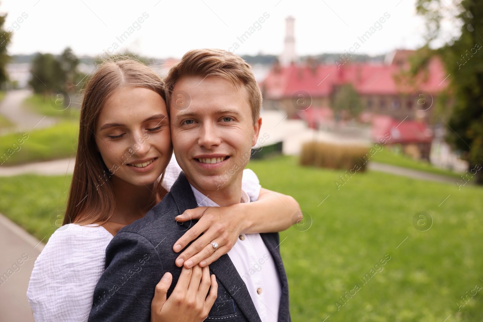 Marriage proposal. Woman with engagement ring hugging her smiling fiance outdoors, space for text Photo of Marriage proposal. Woman with engagement ring hugging her smiling fiance outdoors, space for text
