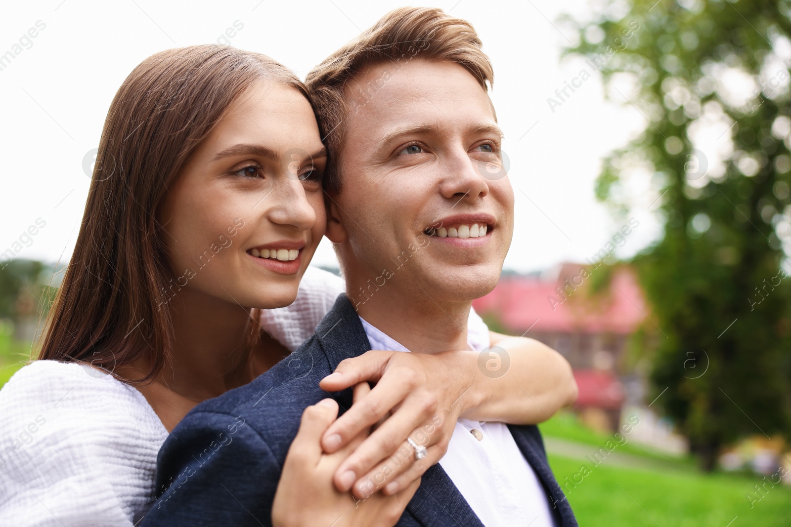 Marriage proposal. Woman with engagement ring hugging her smiling fiance outdoors Photo of Marriage proposal. Woman with engagement ring hugging her smiling fiance outdoors