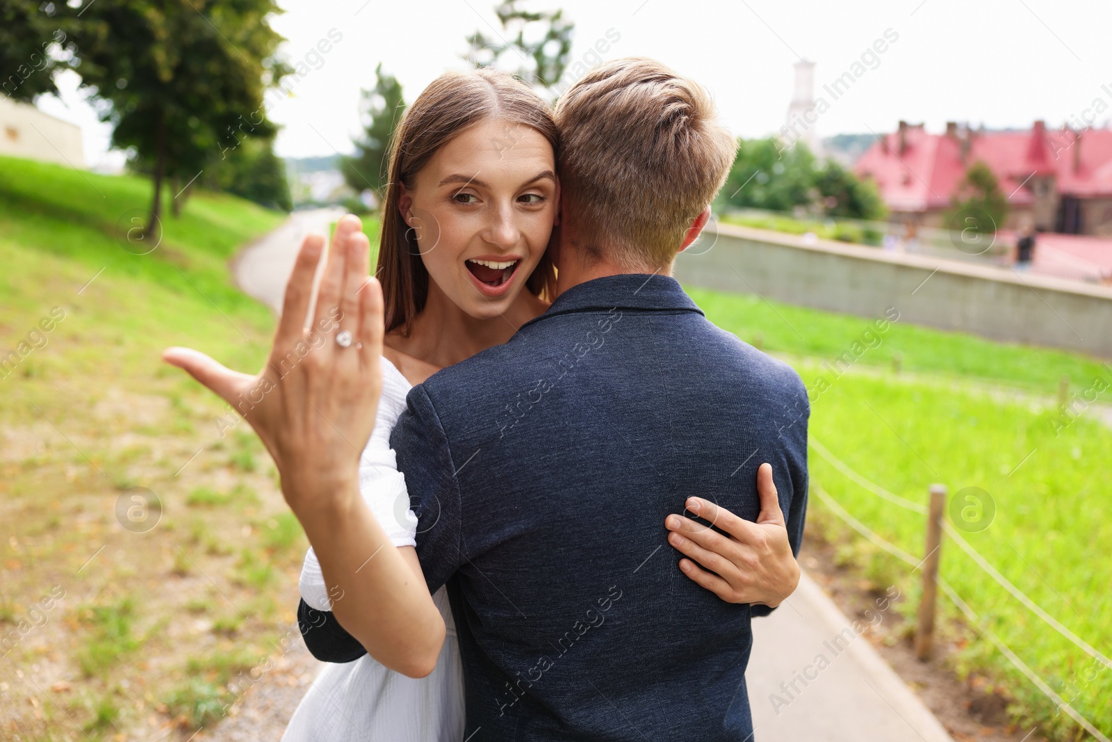 Marriage proposal. Excited woman with engagement ring hugging her fiance outdoors Photo of Marriage proposal. Excited woman with engagement ring hugging her fiance outdoors