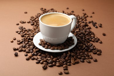 Photo of Cup of hot coffee and beans on brown background, closeup