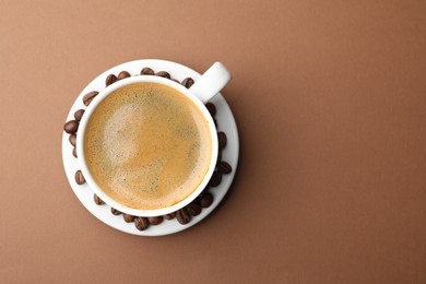 Photo of Cup of hot coffee on brown background, top view. Space for text