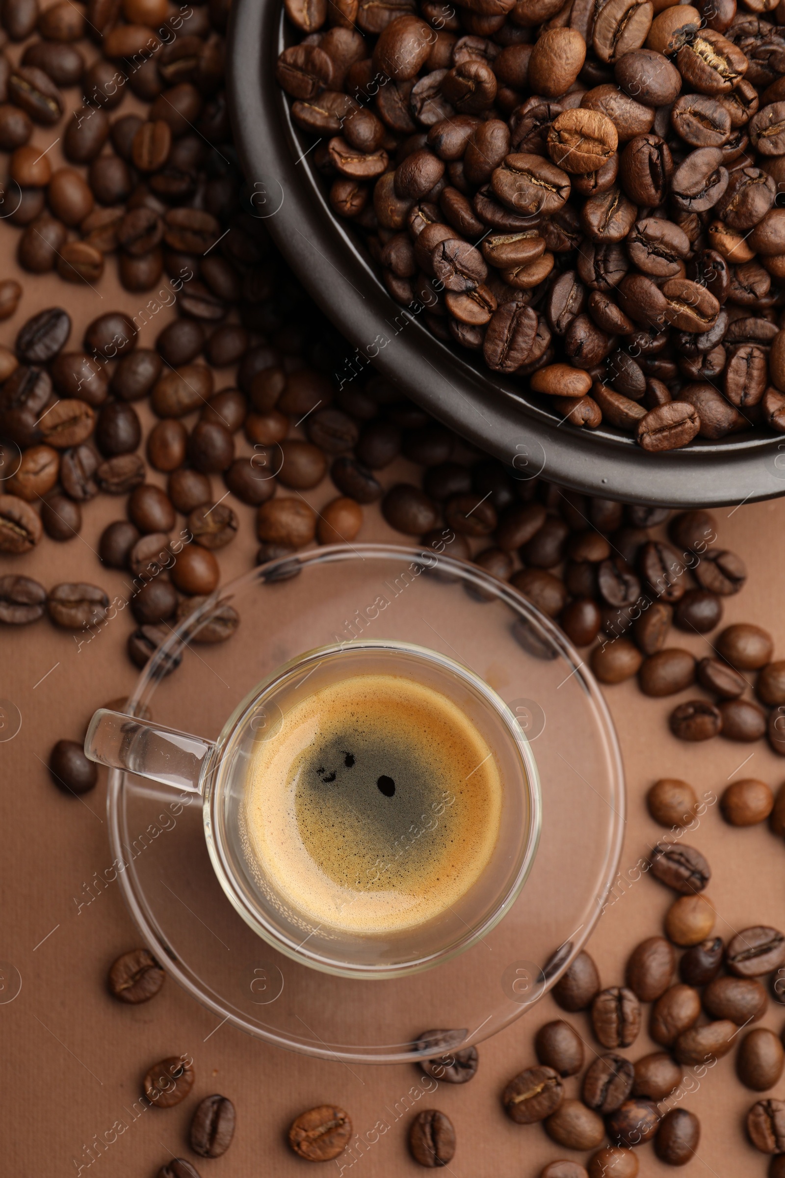 Cup of hot coffee and beans on brown background, flat lay Photo of Cup of hot coffee and beans on brown background, flat lay